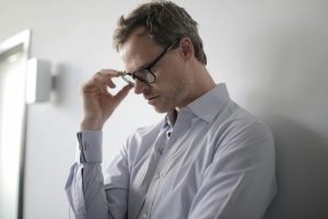 stressed man leaning against a wall